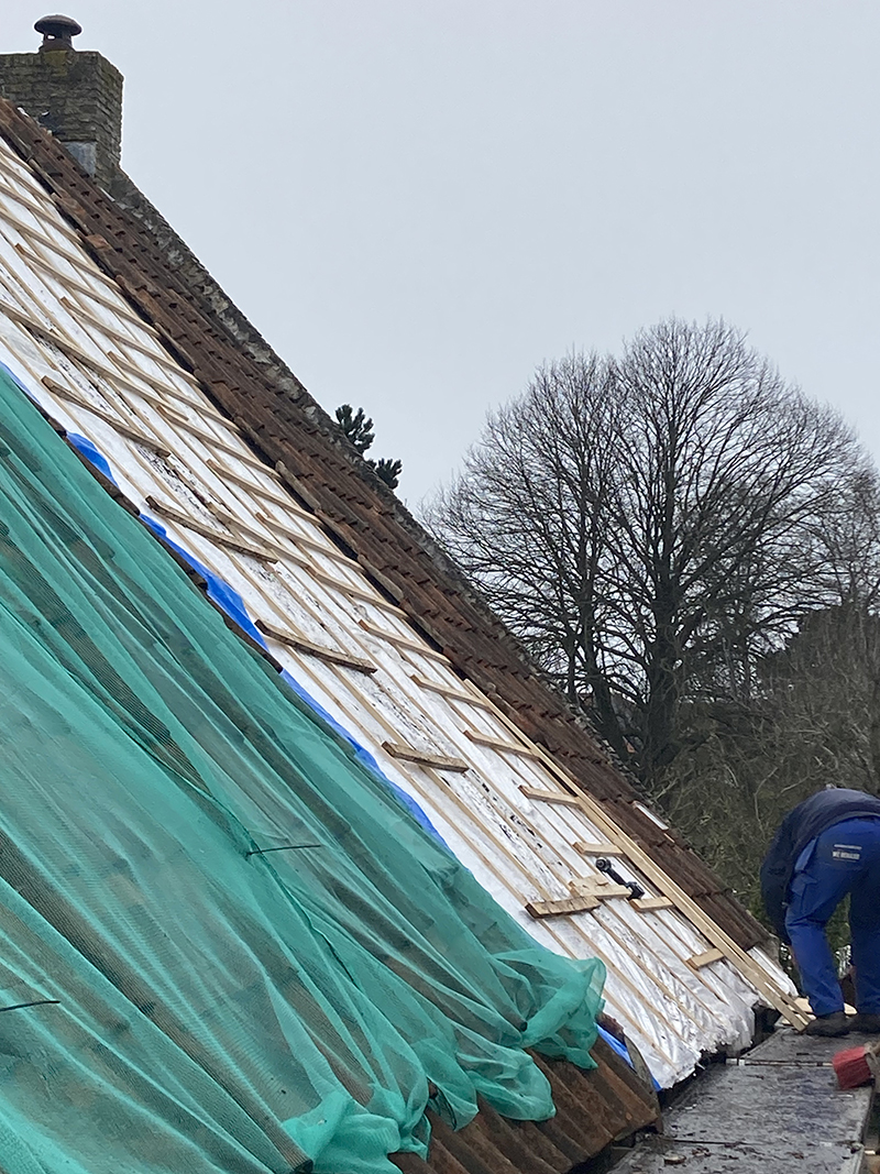 Het net tegen vogels op het dak van een Eilanderhuis aan de Langestreek